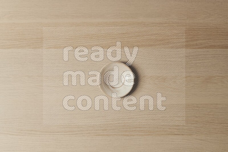 A pottery coaster on light wooden background