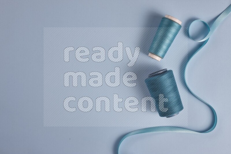 مجموعة من أدوات الخياطة والتفصيل زرقاء اللون على خلفية زرقاء