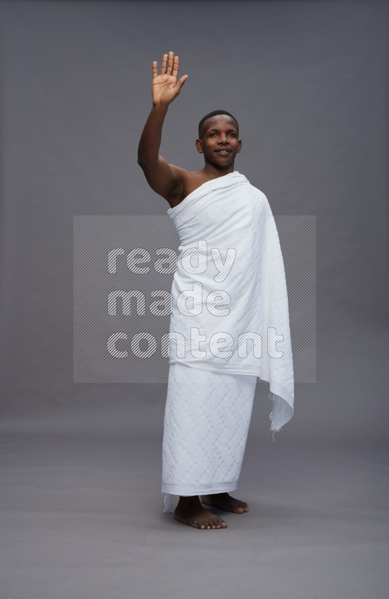 A man wearing Ehram Standing Interacting with the camera on gray background