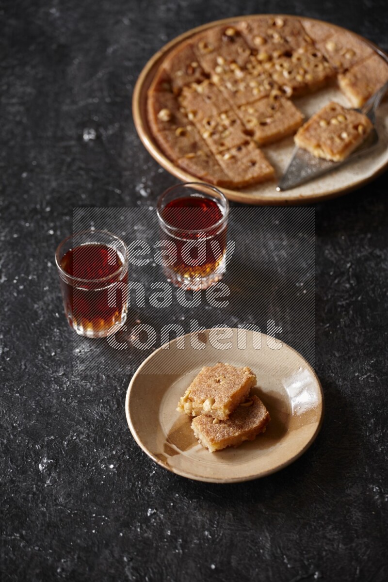 Basbousa with tea in a dark setup