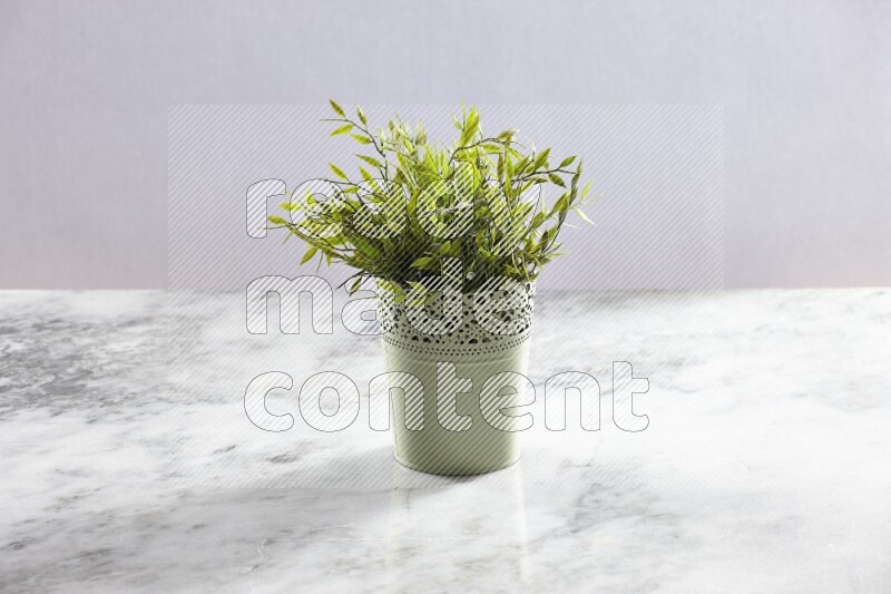 Artificial plant in green decorative pot on grey marble background