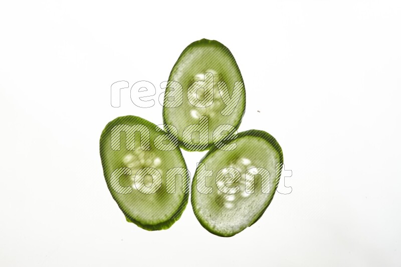 Cucumber slices on illuminated white background