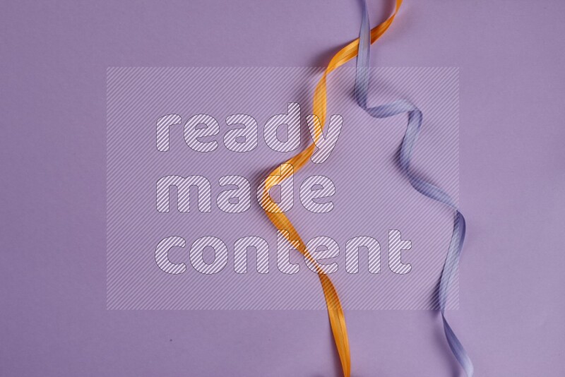 An orange collection of sewing and tailoring tools arranged on a purple background