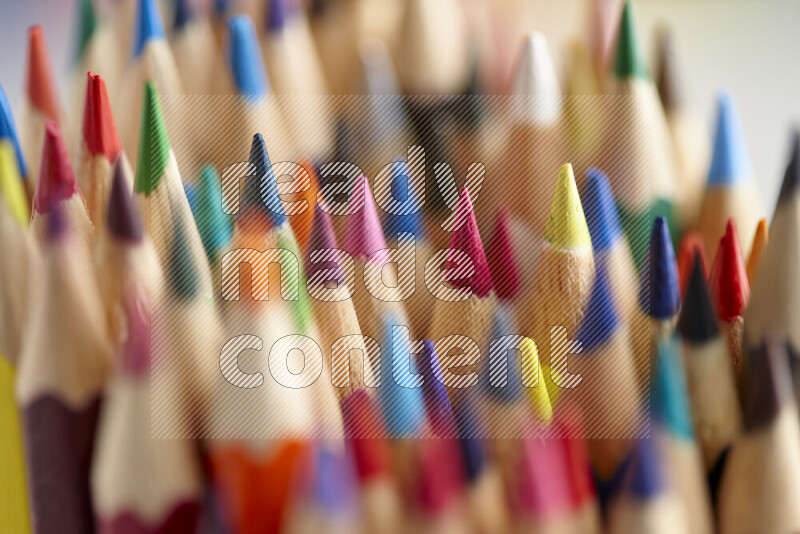 The image captures a close-up of sharpened colored pencils on multicolored background