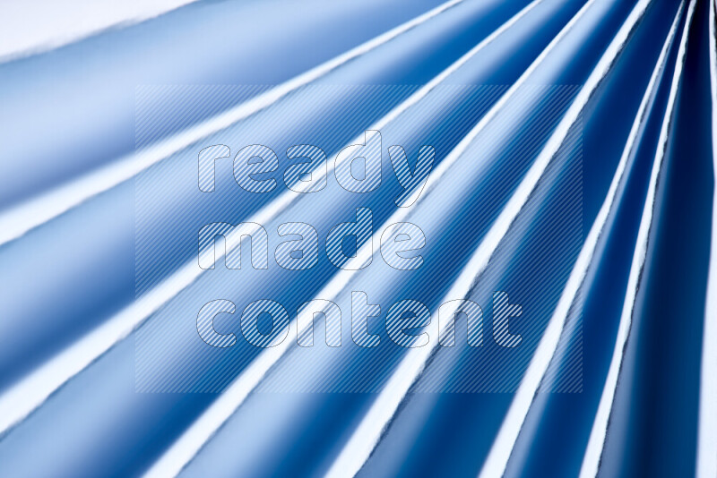 An image presenting an abstract paper pattern of lines in blue and white tones