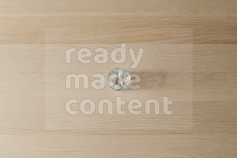 An empty glass cup on light wooden background