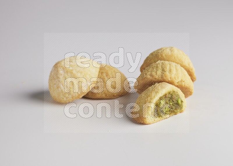 Five Pieces of Maamoul filled with pistachio  paste one of them is cut direct on white background