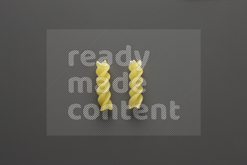 Fusilli pasta on grey background