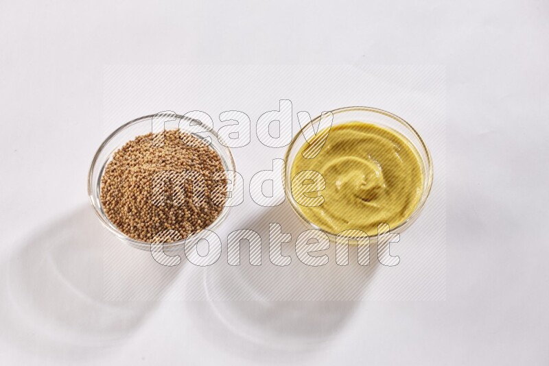2 glass bowls, one full of mustard seeds and the other full of mustard paste on white flooring