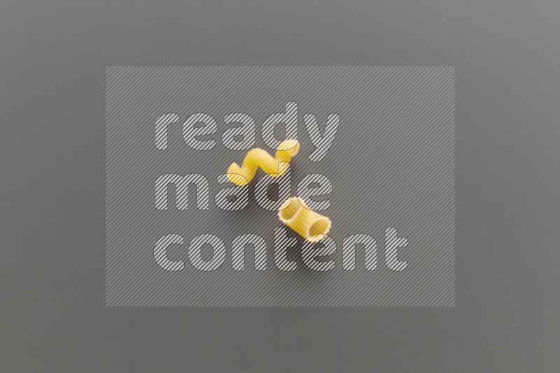 Twist pasta with other types of pasta on grey background