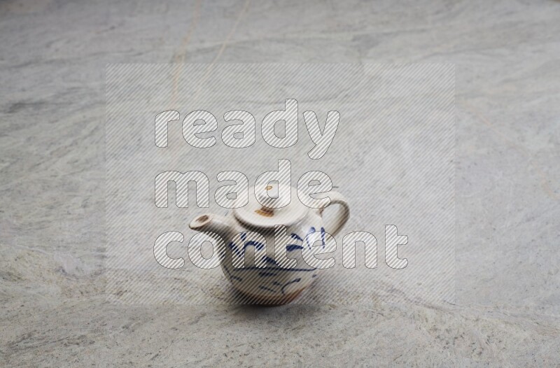 A pottery teapot on grey marble background