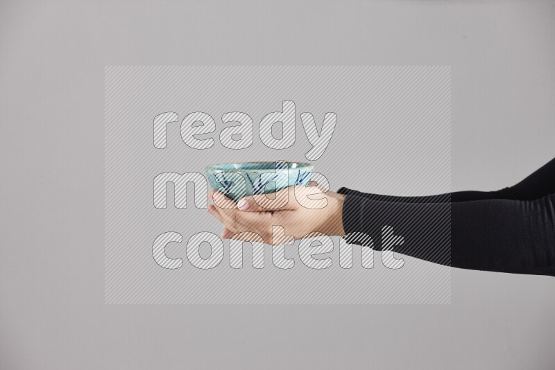 A woman in black abaya holding different pottery essentials in different positions