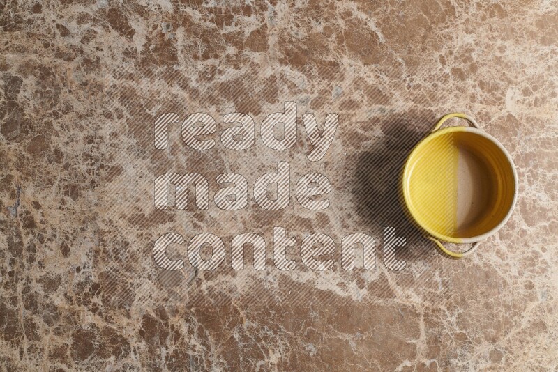 A multicolored pottery bowl on beige marble background