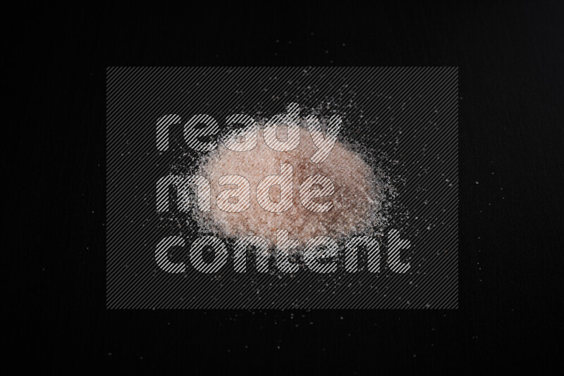 A bunch of fine himalayan pink salt on black background