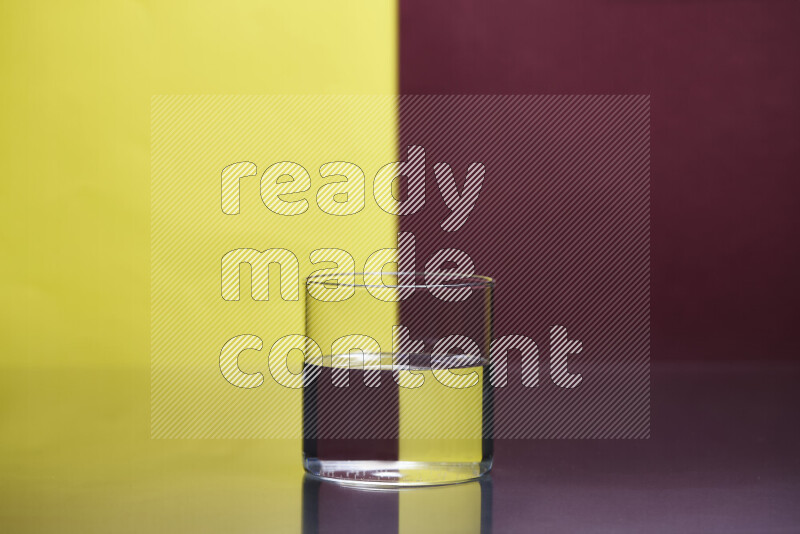 The image features a clear glassware filled with water, set against yellow and dark red background