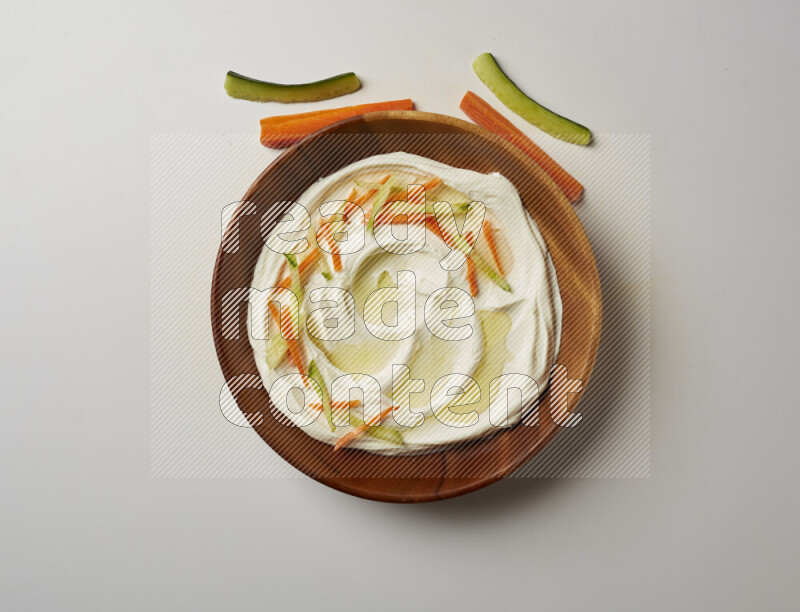 Lebnah garnished with sliced carrots & cucumber in a wooden plate on a white background