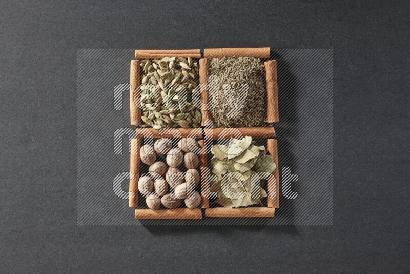 4 squares of cinnamon sticks full of cumin, cardamom, bay laurel leaves and nutmegs on black flooring