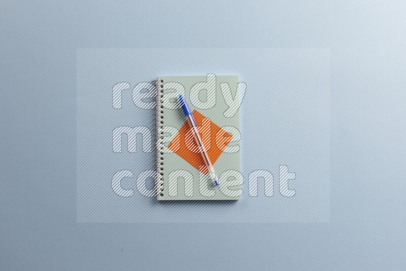 A blue notebook with different school supplies on blue background