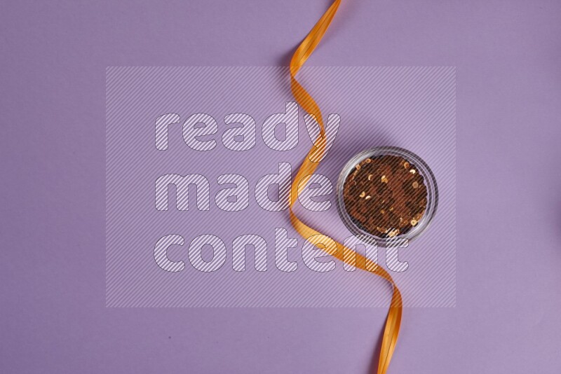 مجموعة من أدوات الخياطة والتفصيل برتقالية اللون على خلفية أرجوانية