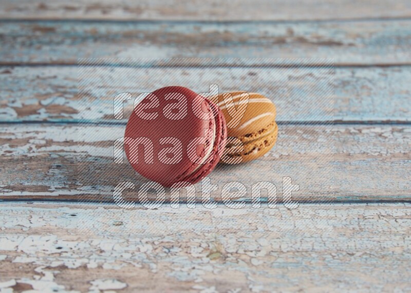 45º Shot of of two assorted Brown Irish Cream, and Red Velvet macarons on light blue background