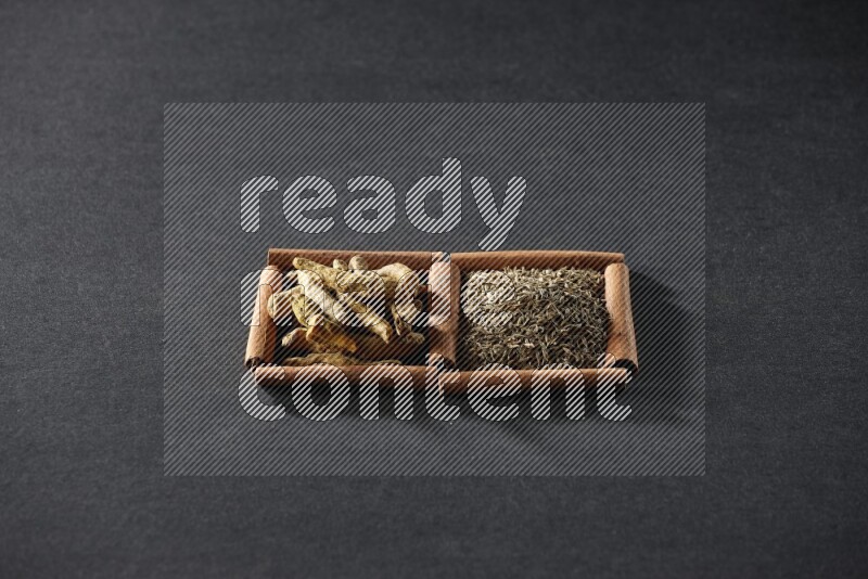 2 squares of cinnamon sticks full of cumin and turmeric fingers on black flooring