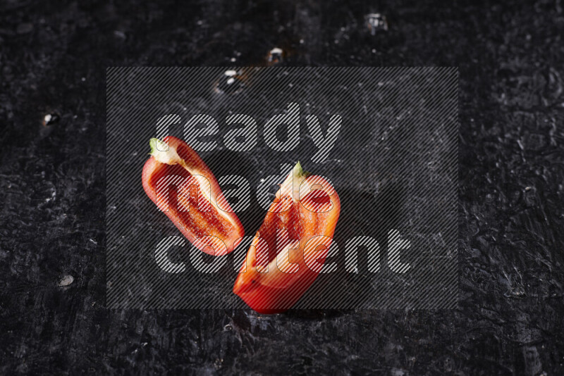 Red bell pepper slices on black background