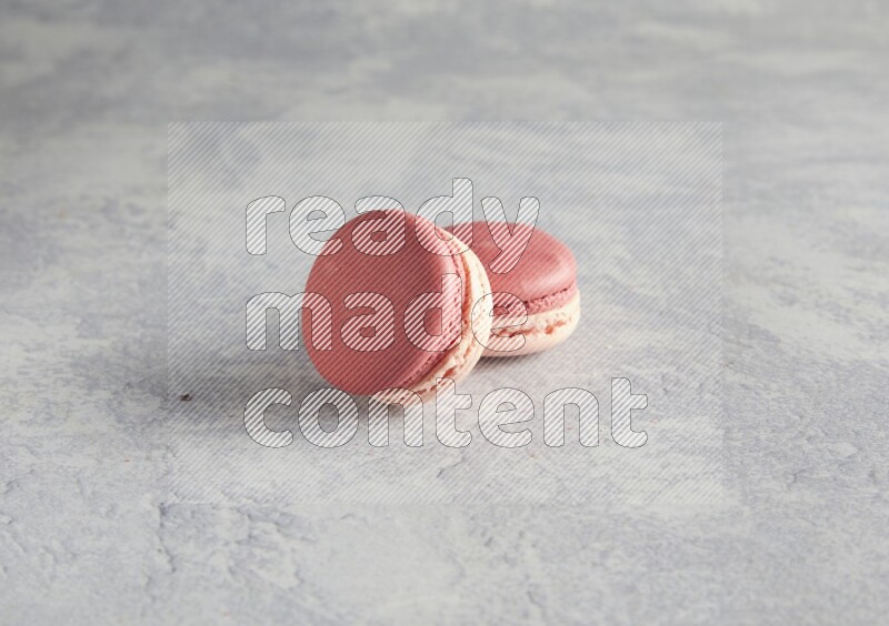 45º Shot of two Pink Litchi Raspberry macarons  on white  marble background