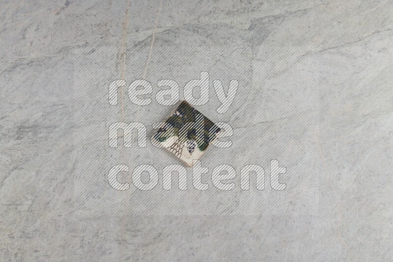 A decorative pottery coaster on grey marble background