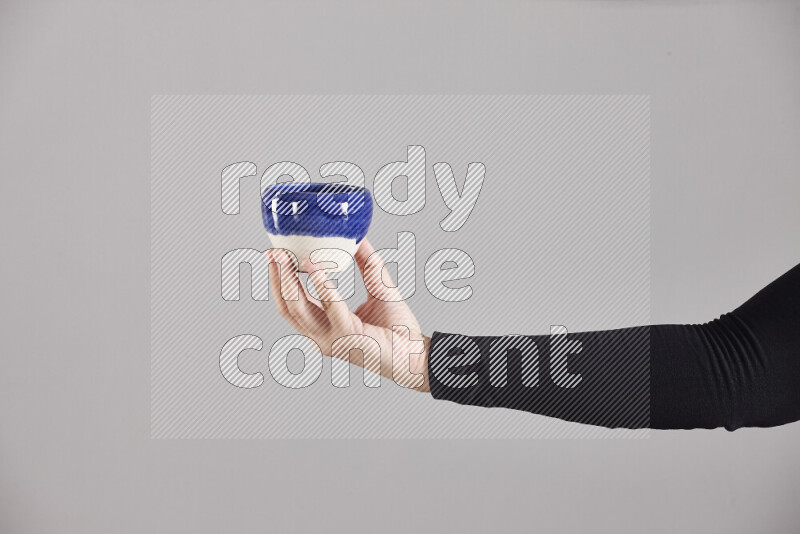 A woman in black abaya holding different pottery essentials in different positions