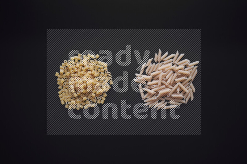 Different pasta types in bunches on black background
