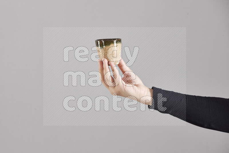 A woman in black abaya holding different pottery essentials in different positions