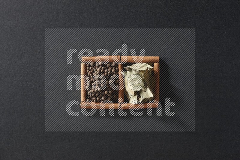 2 squares of cinnamon sticks full of allspice and bay laurel leaves on black flooring