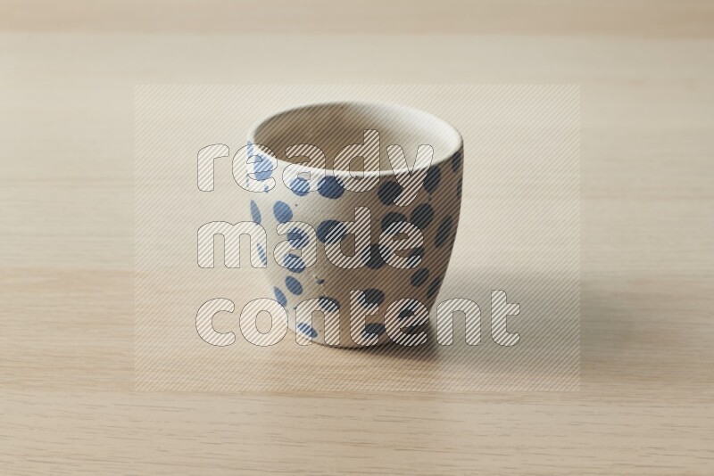 A pottery cup on light wooden background