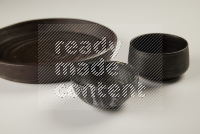 black pottery plate and black bowls on white background