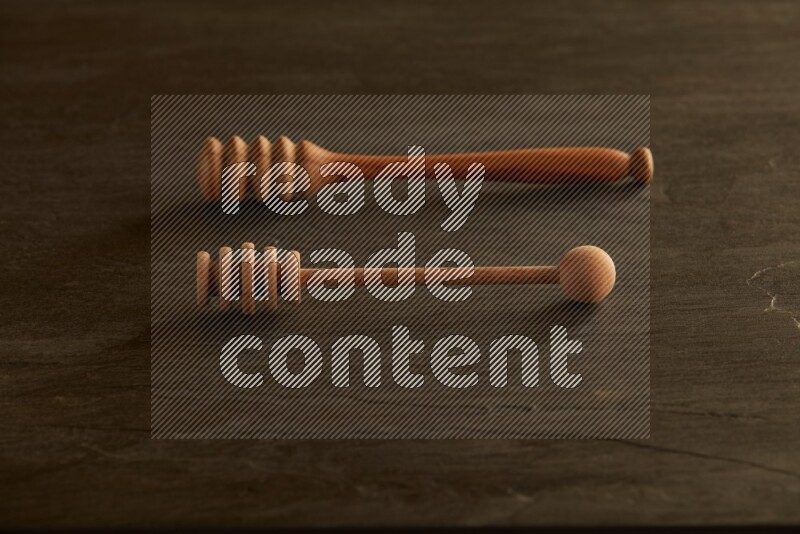 Wooden honey dipper on black slate background