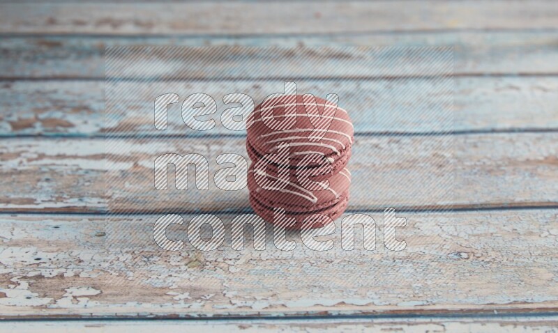 45º Shot of two Red Poppy Flower macarons on light blue wooden background