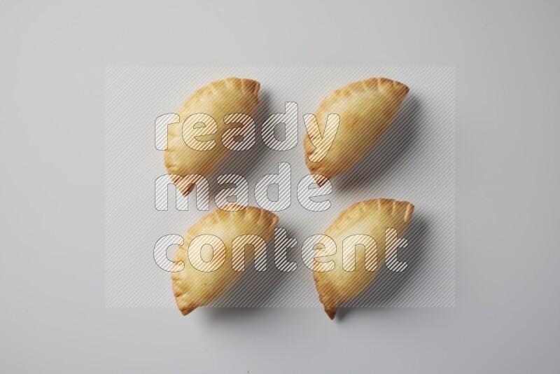 Four fried sambosa from a top angle on a white background
