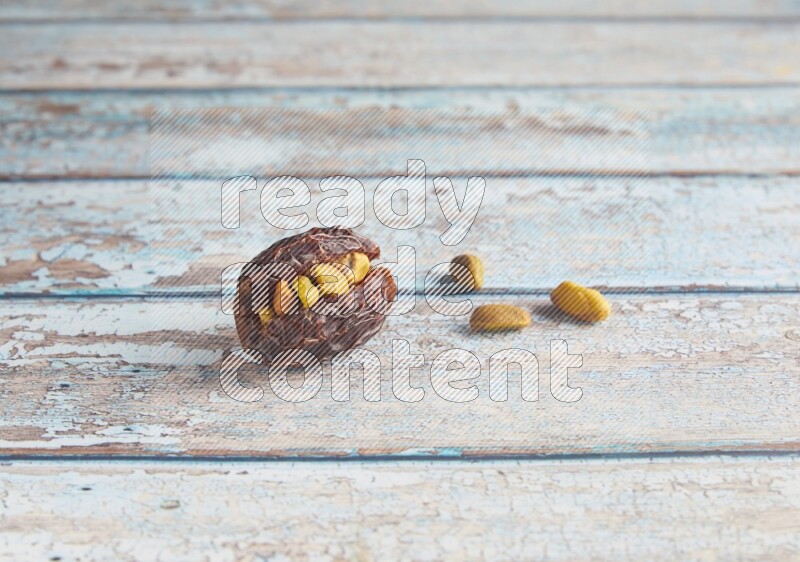 pistachio stuffed madjoul date on a light blue wooden background