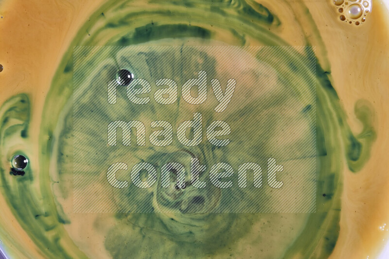 A close-up of abstract swirling patterns in orange and green