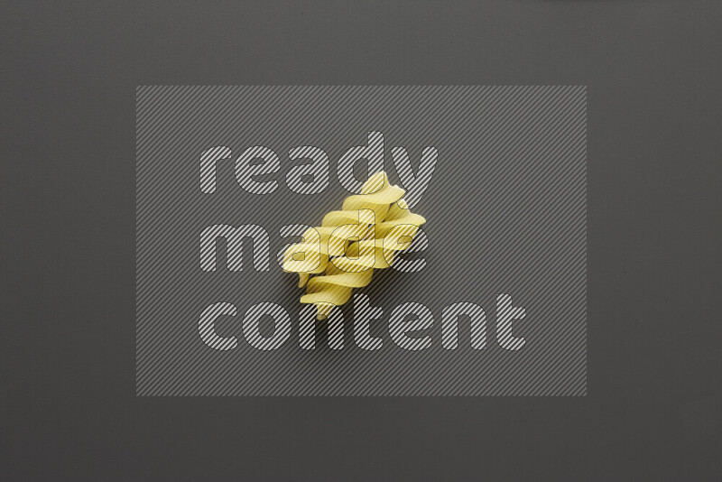 Fusilli pasta on grey background