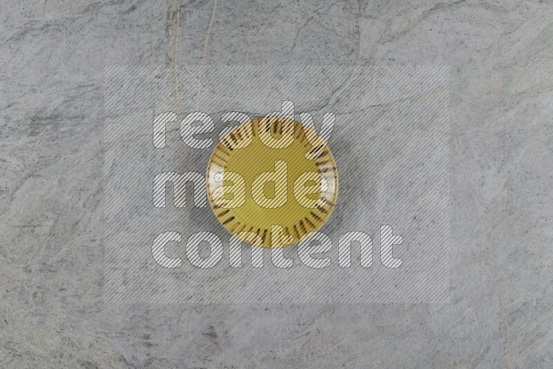 A multicolored pottery plate on grey marble background