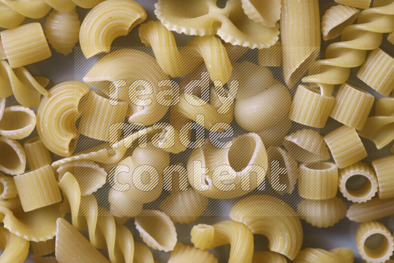 Different pasta types on light blue background