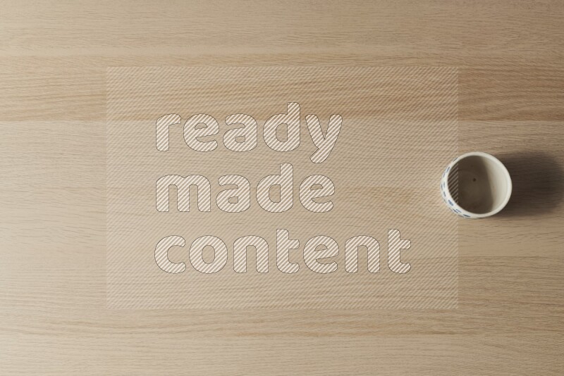 A pottery cup on light wooden background
