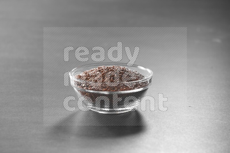 حبوب الكتان في وعاء زجاجي علي خلفية سوداء