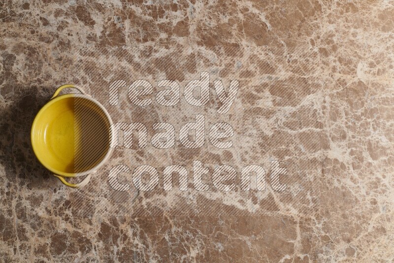 A multicolored pottery bowl on beige marble background