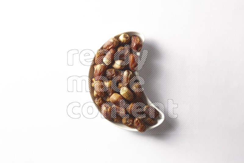 Dates in a crescent pottery plate on white background
