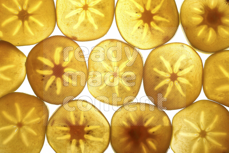 Persimmon slices on illuminated white background