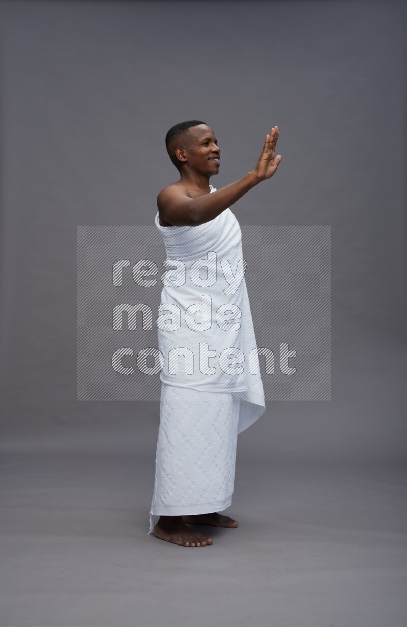 A man wearing Ehram Standing Interacting with the camera on gray background