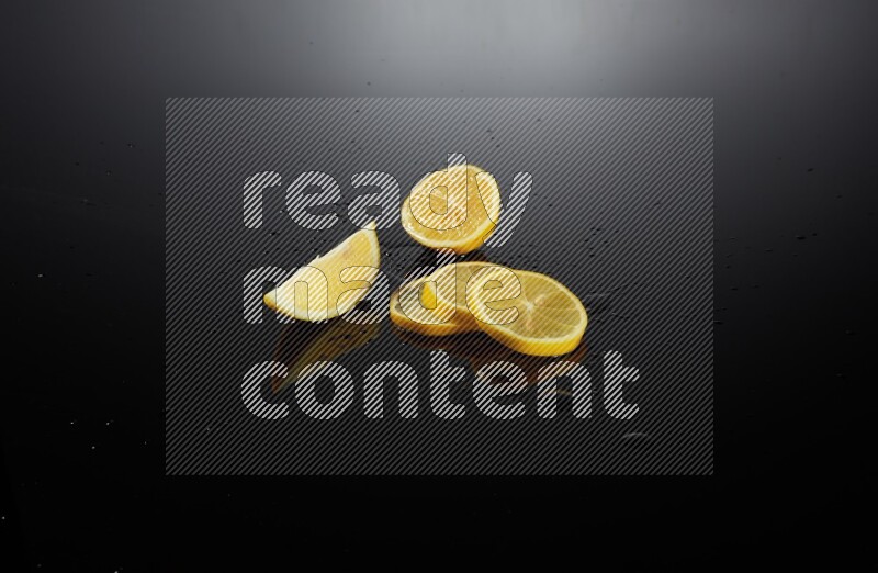 Lemon slices with water drops, and droplets on black background