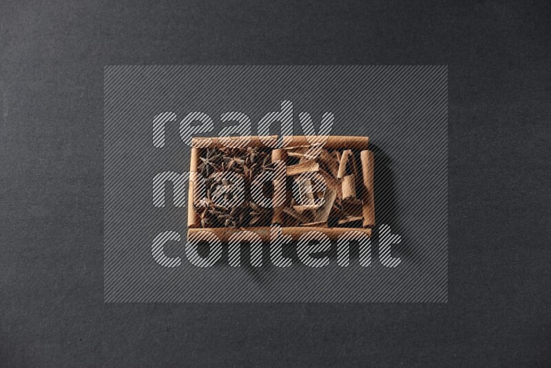 2 squares of cinnamon sticks full of star anise and cinnamon on black flooring